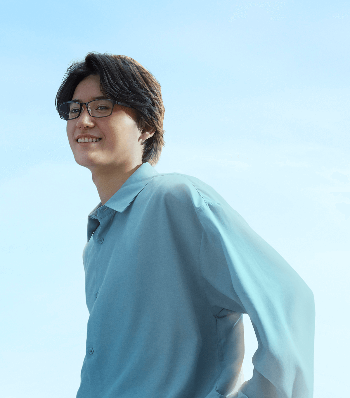 AIRSTYLE のフレームをかけ、青空を背に微笑む男性