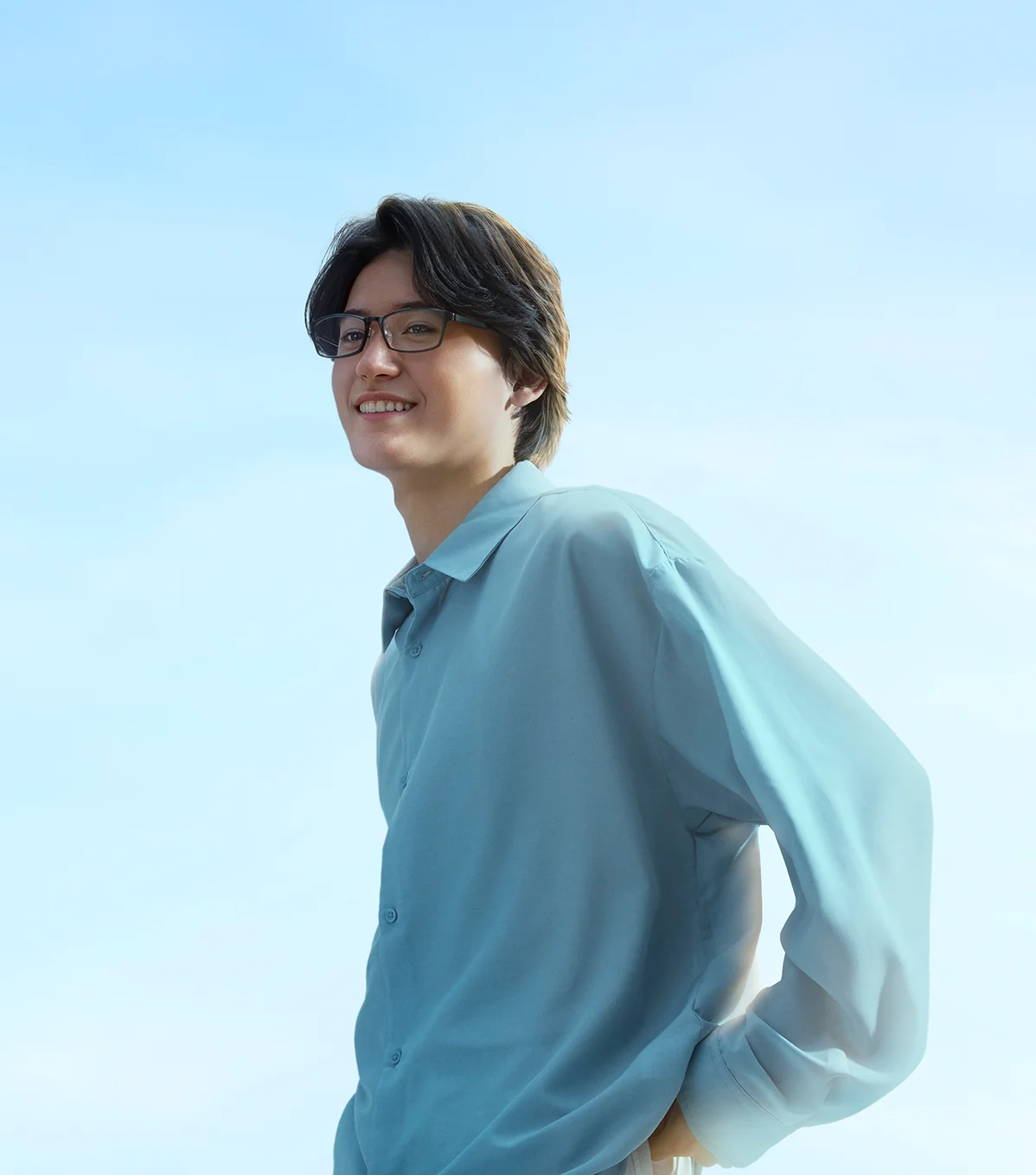 AIRSTYLE のフレームをかけ、青空を背に微笑む男性