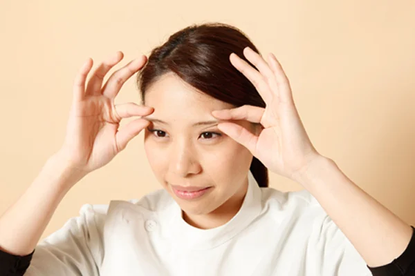 眉をつまむ