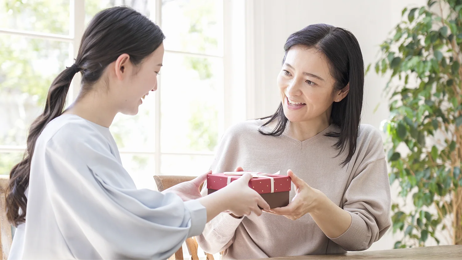 母親にプレゼントを手渡す娘