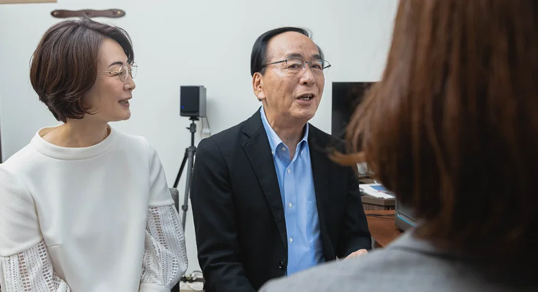 スタッフから聴力測定の結果の説明を受ける夫婦