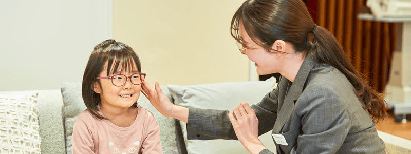 女の子のメガネをフィッティングするスタッフ