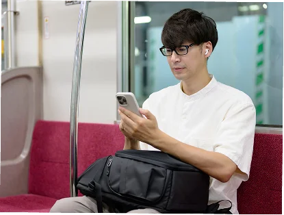 電車内でスマホを見る男性