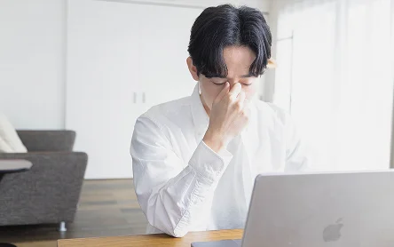 目の疲れを感じる男性